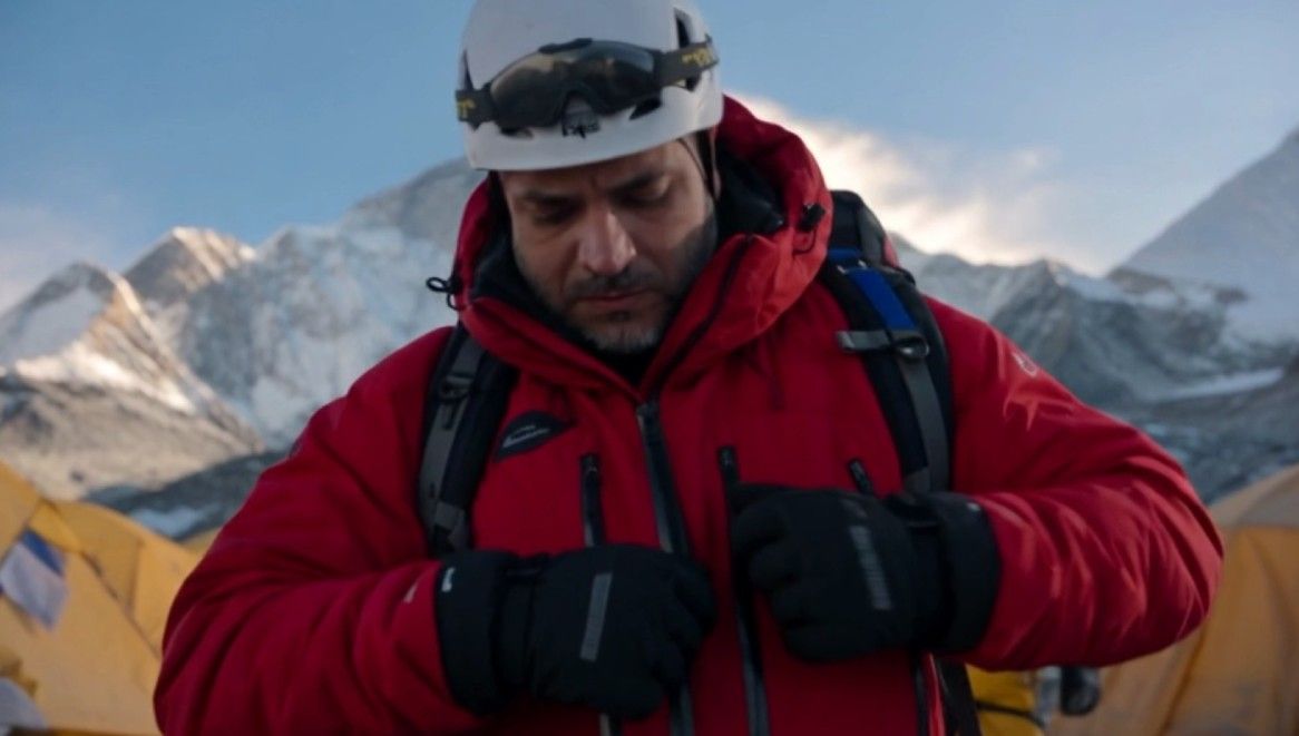 Camp de base. Un alpiniste ajuste sa veste. Le silence, puis le départ.