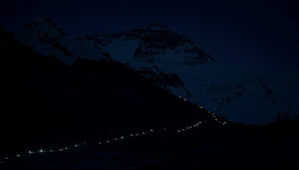 Une file de frontales s'étire dans la nuit, vers la face nord.